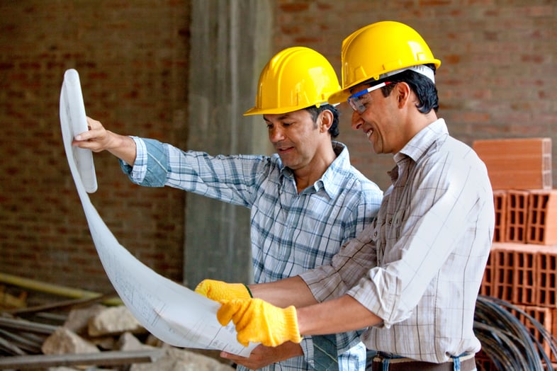 Architects at a construction site looking at blueprints