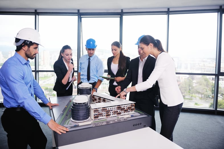 business people group on meeting and presentation  in bright modern office with construction engineer architect and worker looking building model and blueprint planbleprint plans